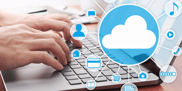 Hände, die auf einem Laptop schreiben und daneben eine digitale Wolke in blauweiß.